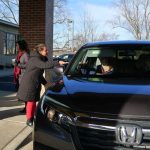 carrier law team members meet guests at their car to give them cookies and cocoa at the 2021 event