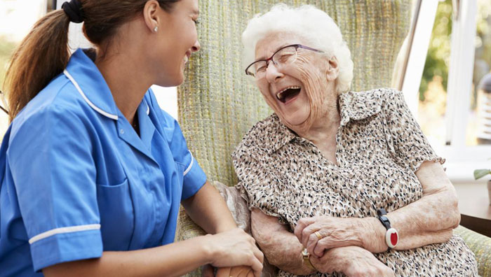 a nurse visits with an elderly woman in hospice care